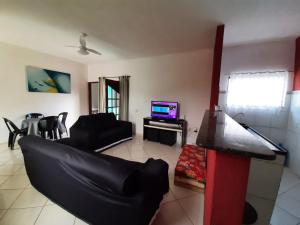 a living room with a couch and a television at Vivamar2 in Cabo Frio