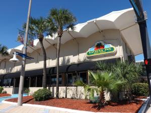 een restaurant met palmbomen voor een gebouw bij Turquoise Beach Retreat~King Bed~Daytona Beach in Daytona Beach
