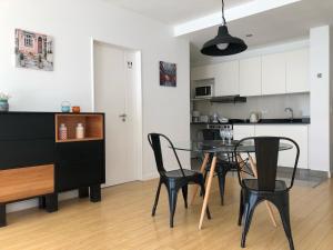 Cozy Studio in Palermo Soho with security 24 hs في بوينس آيرس: مطبخ وغرفة طعام مع طاولة وكراسي