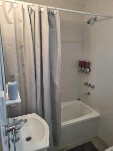 łazienka z zasłoną prysznicową, wanną i umywalką w obiekcie Andoli 2 w mieście Santa Rosa