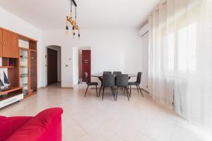 een woonkamer met een rode bank en een tafel en stoelen bij L'approdo di Ermione in Francavilla al Mare