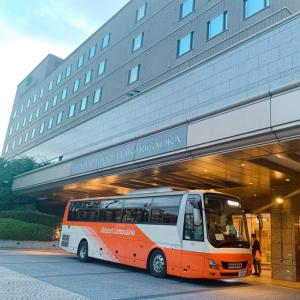 an orange and white bus parked in front of a building at Hotel Cadenza Tokyo in Tokyo