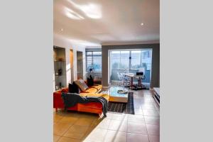 una sala de estar con un sofá y una mesa en Summerstrand Boutique Beach Apartment, en Summerstrand