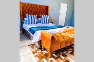a bedroom with a large bed and a couch at Summerstrand Boutique Beach Apartment in Summerstrand