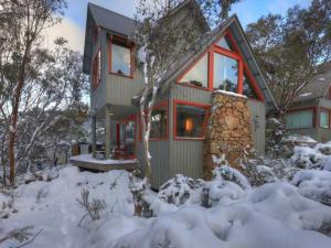 a house with snow in front of it at Indi Chalet in Thredbo