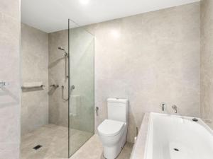 a bathroom with a toilet and a glass shower at Cove 802 with Ocean Views in Forster