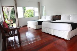 1 Schlafzimmer mit 2 Betten und Holzboden in der Unterkunft RimPai Cottage in Pai