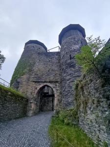 een oud stenen gebouw met een poort en een stenen muur bij Burgapartment Felsenhäuschen in Monschau