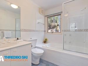 a white bathroom with a toilet and a sink at Kaella in Thredbo