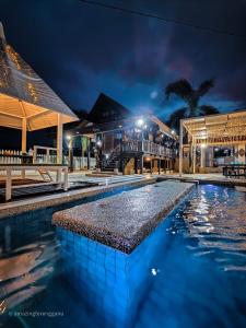 una piscina frente a un edificio por la noche en Villapadu Desa en Kuala Terengganu