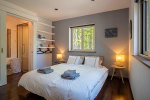 een slaapkamer met een wit bed en handdoeken bij Forest Hideaway in Niseko