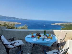 una mesa azul con comida y bebida en un balcón con vistas al océano en Ustrine view en Ustrine