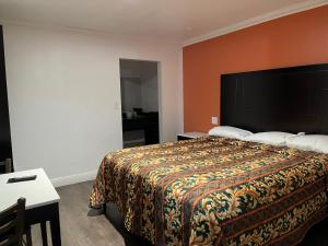 a bedroom with a large bed with an orange wall at Studio 6 Oakland CA San Francisco Berkeley Area in Oakland