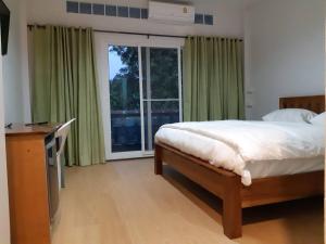1 dormitorio con cama y ventana grande en แสงสินธ์เฮ้าส์ Shangsin House, en Mae Hong Son