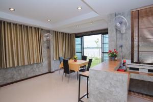 cocina y comedor con mesa y sillas en Riverview Loft house, en Uthai Thani