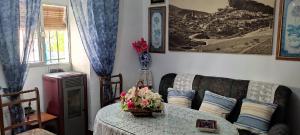 a living room with a couch and a table with flowers at Casa Lola in Montefrío