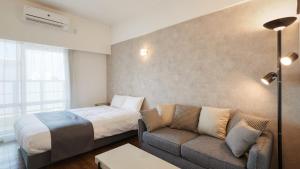 那霸New Normal Hotel in NAMINOUE ニューノーマルホテルイン波の上的酒店客房,配有床和沙发 更多37张照片