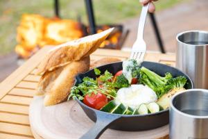 a plate of food with a pan of vegetables and toast at agris FURANO 01 FARM GUEST HOUSE in Nunoppe