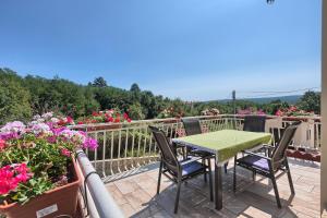 a table and chairs on a balcony with flowers at Villa Emma in Lanišće