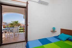1 Schlafzimmer mit einem Bett und einem Balkon mit einem Tisch in der Unterkunft Apartments Brankica in Vantačići