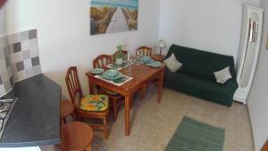 a dining room with a table and a couch at Verde casa eden in Tías