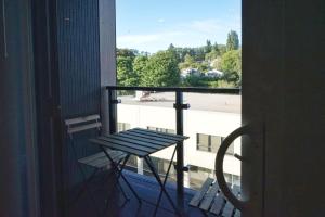 a bench on a balcony with a view of a building at University of Washington New Apartment Studio w/kitchen and balcony in Seattle