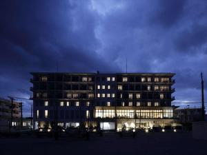 a large building with lit up windows at night at Hotel Locus in Miyako Island