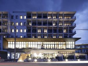 a large white building with many windows at night at Hotel Locus in Miyako Island