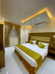 a large bedroom with a large bed with green sheets at منازل بلقيس للشقق المخدومة فرع أ جاء in Hail +24 photos