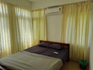 a bed in a bedroom with drapes at BMRAN Apartment R in Ernakulam