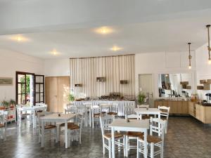 a dining room with white tables and white chairs at Asteri Hotel in Livadi +36 photos