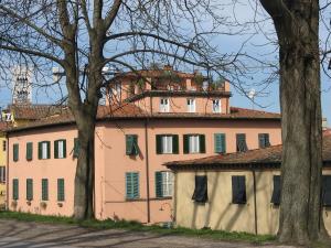een roze gebouw met bomen ervoor bij Le MURA MEDIEVALI in Lucca