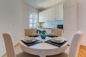 a dining room with a table and chairs and a kitchen at House Catania in Mali Lošinj