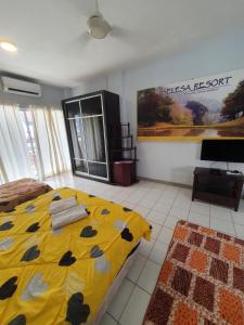 ein Schlafzimmer mit einem gelben Bett und einem TV in der Unterkunft Selesa Hillhomes Golf resort - T10GGB in Bentong