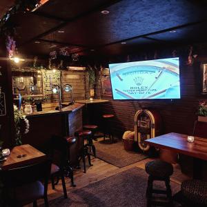 a bar with tables and a tv in a room at Serendipity House in Derry Londonderry