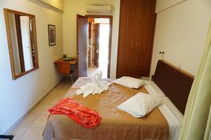a hotel room with a bed, table, and window at Sitia Bay in Sitia