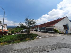 ein weißes Gebäude mit einem roten Dach auf einer Straße in der Unterkunft Selesa Hillhomes Golf resort - T10GGB in Bentong