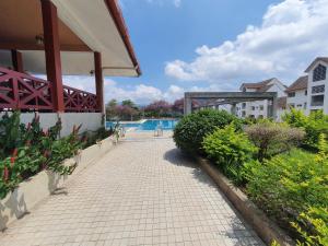 une passerelle en briques à côté d'un bâtiment avec piscine dans l'établissement Selesa Hillhomes Golf Resort - T11GGB, à Bentong