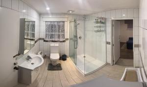 uma casa de banho com um chuveiro, um WC e um lavatório. em Self Contained En-Suite Private Bathroom, Private Entrance, Close to Shops & Hospital Homestay em Hamilton
