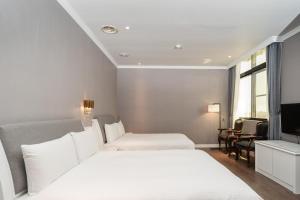 宜蘭市にあるYilan Fu Hsiang Hotelのベッド2台とテレビが備わるホテルルームです。