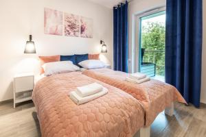 a bedroom with a bed with two towels on it at Residence Polanica z sauną, Sun & Snow in Polanica-Zdrój