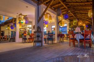 Un restaurante con mesas, sillas y luces. en El Fuerte Beach Apartments, en Mahahual