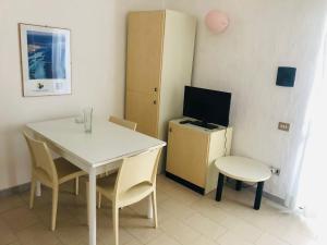 a small room with a white table and a television at NRH Stintino Beach Garden in Stintino