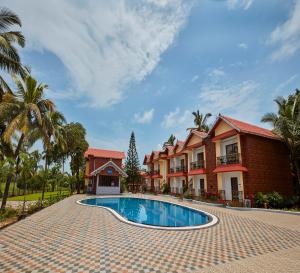 a resort swimming pool in front of a building at Sea Queen Beach Resort & Spa in Colva