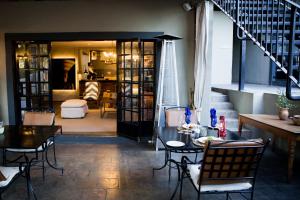 une chambre avec une table et des chaises ainsi qu'un salon dans l'établissement Olive Grove Guesthouse, à Windhoek