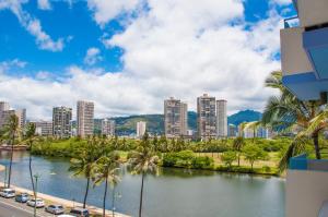 a view of a city with palm trees and a river at Holiday Surf Hotel (with full kitchen) in Honolulu