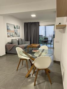 ein Wohnzimmer mit einem Glastisch und Stühlen in der Unterkunft Enjoy Las Canteras in Las Palmas de Gran Canaria