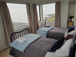 een slaapkamer met 2 bedden en een groot raam bij Best Waterfront Deck in Riverton in Riverton