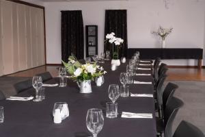 a long table with glasses and flowers on it at Centennial Court Hotel in Alexandra