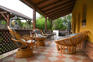 un patio con sillas y una mesa en un porche en Fiesta Balaton Villa, en Balatonszárszó